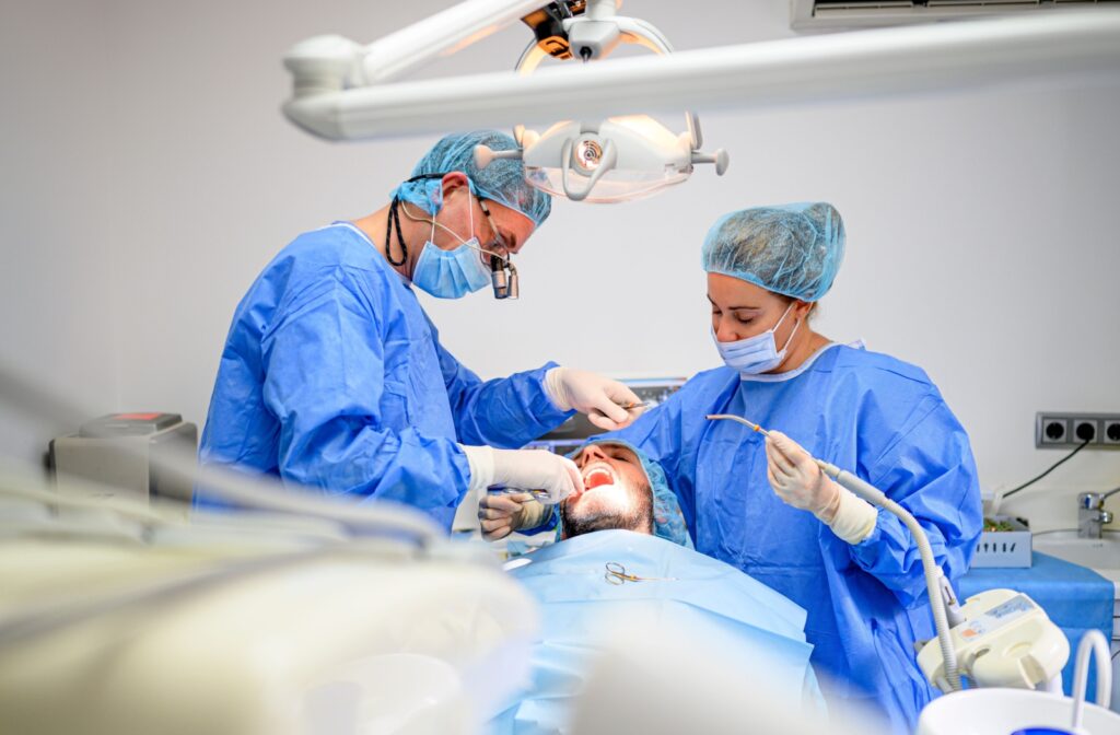 2 dentists prepare a patient for surgery to treat more advanced gum disease.